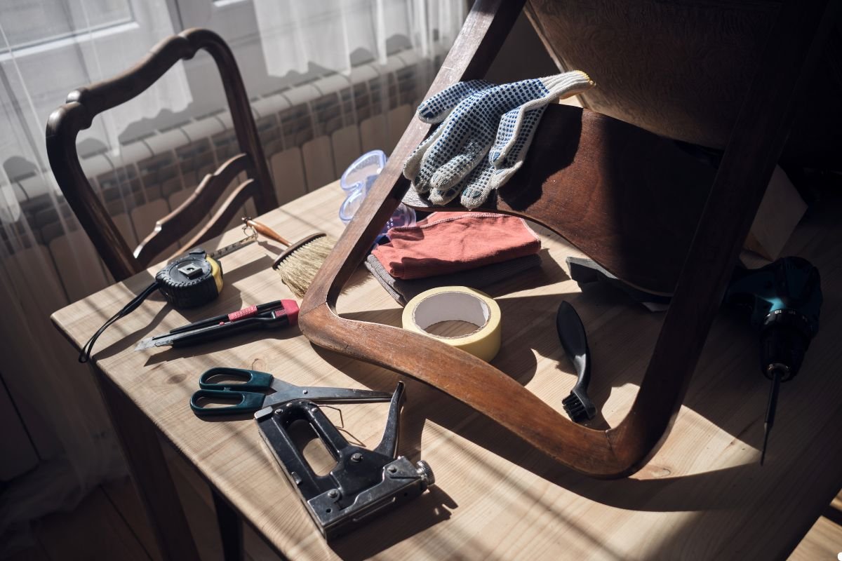 A cluttered table featuring an assortment of tools, such as pliers and screwdrivers, alongside miscellaneous items. 